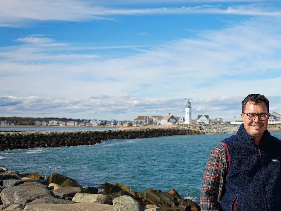 Ted Healey on the jetty in Scituate with the lighthouse behind him